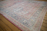 Distressed vintage Sparta carpet corner with faded raspberry, denim blue floral borders.