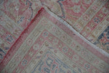 Vintage distressed Sparta rug fold, showing worn pink-beige pile, fringed edge, and its foundation.