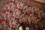 Vintage Bijar rug with repeating rose bouquets, abrashes, in cherry red, blue, green, and pink.