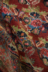 Intricate rose bouquets and rich abrashes in cherry red, blue, and pink on a vintage Bijar rug.