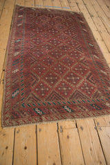 Distressed Belouch runner: raspberry burgundy field, geometric guls, and muted teal accents.