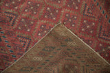 Distressed Belouch rug's raspberry burgundy geometric pile and hand-knotted foundation.