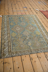 Distressed geometric patterns, faded pile, and wave border on antique Caucasian rug.