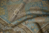 Antique Distressed Caucasian Rug: worn texture showcasing geometric guls, dusty blue, sand, and olive.