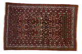 Vintage Belouch rug with a pomegranate garden design in charcoal, cherry red, and dark gold tones.