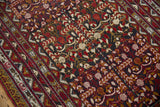 Close view of the pomegranate garden motif with ribboned vines in red and gold.