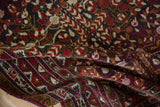 Draped vintage Belouch rug showing the dense pomegranate garden motif in red, gold, and charcoal.
