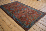 Vintage Mehreban rug with brick red field, sky blue arabesque border, and serpent motif.