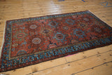Vintage Mehreban rug with brick red field, sky blue serpent motif border, and fringe.