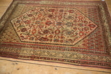 Angled view of a vintage Serbend rug showing its allover Herati design and time-softened patina.
