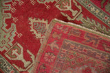 Cherry red and olive green Oushak rug pile showing woven foundation and intact selvage.