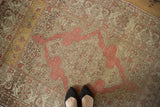 Worn texture of a distressed Kayseri rug, showing a blush scalloped medallion and saffron yellow corner.
