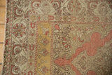 Corner of a distressed Kayseri rug showing its ribboned floral borders and time-softened low pile.