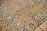 Corner detail of a distressed Kayseri rug showing its scrolled leaf borders and saffron panel.