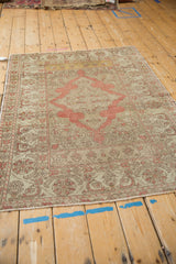 Distressed vintage Kayseri rug with a soft blush medallion, viewed from a high angle.
