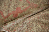 A draped view of a vintage Kayseri rug highlights its distressed texture and muted floral design.