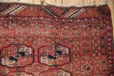 Corner of a vintage Belouch rug showing multi-layered borders with Turkmen-style geometric motifs.