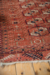 Angled view showing the geometric ram's horn and pawn design motifs of a vintage Belouch rug.