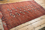 Full length view of a vintage Belouch rug with double columns of Turkmen geometric medallions.