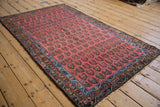 Corner of a vintage Hamadan rug showing blush field, staggered boteh motifs, and sapphire blue borders.