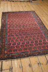 Blush field with staggered boteh, sapphire blue border, and hand-knotted fringe on vintage Hamadan.