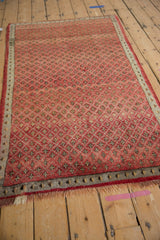 Vintage Oushak rug detail: repeating cherry red blossom pattern and oxidized silver border.