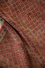 Folded Oushak rug with abrash, highlighting repeating blossom floral motifs in cherry red and oxidized silver.