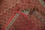 Hand-knotted cherry red quatrefoil patterned Oushak rug corner, showing original selvage and fringe.