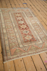 Distressed Melas rug detail, dragon border and serrated diamond medallions in dusty red and ivory.