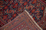 Vintage Turkmen rug runner corner with geometric borders, Herati pattern, and fringe.