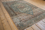 Exposed foundation and faded geometric Herati motifs on a vintage distressed Hamadan rug corner.