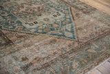 Distressed Herati-inspired geometric pattern in dusty teal, pale mauve, and faded brown.