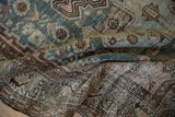 Distressed Hamadan rug detail showing worn pile, visible foundation, dusty teal, brown.