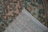 Worn geometric pile and hand-knotted foundation of a vintage distressed Hamadan rug.