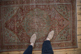 Distressed Josan Sarouk rug, muted red ground, slate blue-green scalloped medallion with vinery.