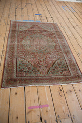 Distressed Josan Sarouk rug with faded red medallion and blue-green floral design.
