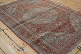 Distressed Josan Sarouk rug corner showing dragon vine border and fading blue-green motifs.