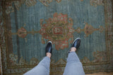 Distressed Malayer rug, faded medallion in pale raspberry red on abrashed blue field.