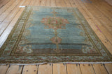 Distressed fringe and intricate border patterns with abrashed blue and brown field.