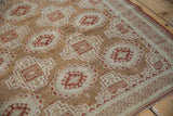 Angled close-up on the unusual maze-like pawn motif border of a distressed Belouch rug.