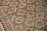 The pawn motif border and geometric guls of a distressed Belouch rug in copper and ivory.