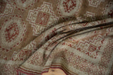 A distressed Belouch rug's soft, pliable weave with geometric guls in terracotta and cream.