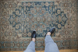The decorative, time-softened texture of a vintage Persian Hamadan rug in dusty blue and beige.
