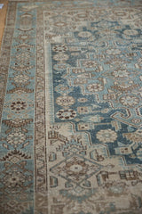 Evenly worn low pile on a vintage Hamadan rug, detailing the blue and beige blossom border design.