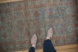 Distressed vintage Belouch runner showcasing faded sapphire blue and terracotta gul patterns.