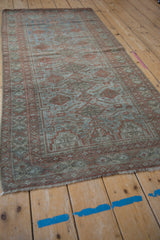 Fringed end of the distressed Belouch runner, revealing worn foundation with sapphire and terracotta.