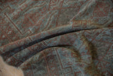 Folded texture of the distressed Belouch runner with muted terracotta and blue patterns.