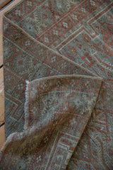 Close-up of distressed Belouch runner's worn pile, revealing terracotta and sapphire blue gul motifs.