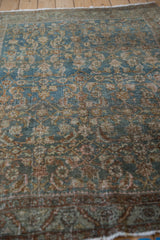 Vintage Persian Bijar rug's textured dusty blue Herati pattern, showing wear and visible foundation.