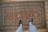 Standing on a distressed antique Shirvan rug with copper and ivory Perpedil motifs.